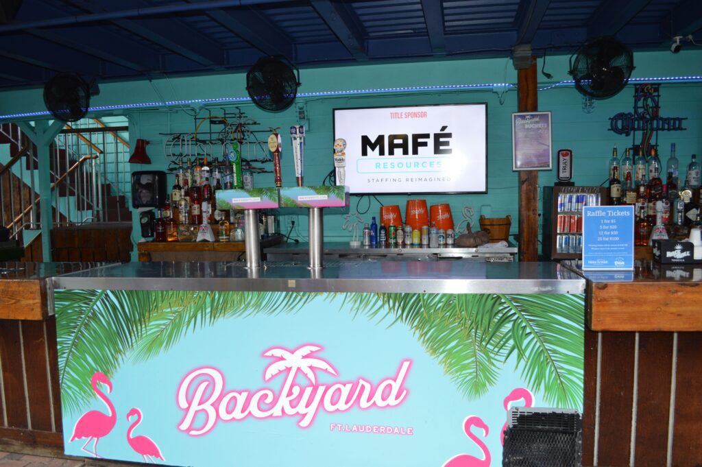 A bar counter with beverages in the back