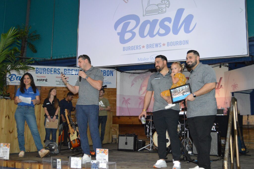 Three man and a kid standing on stage