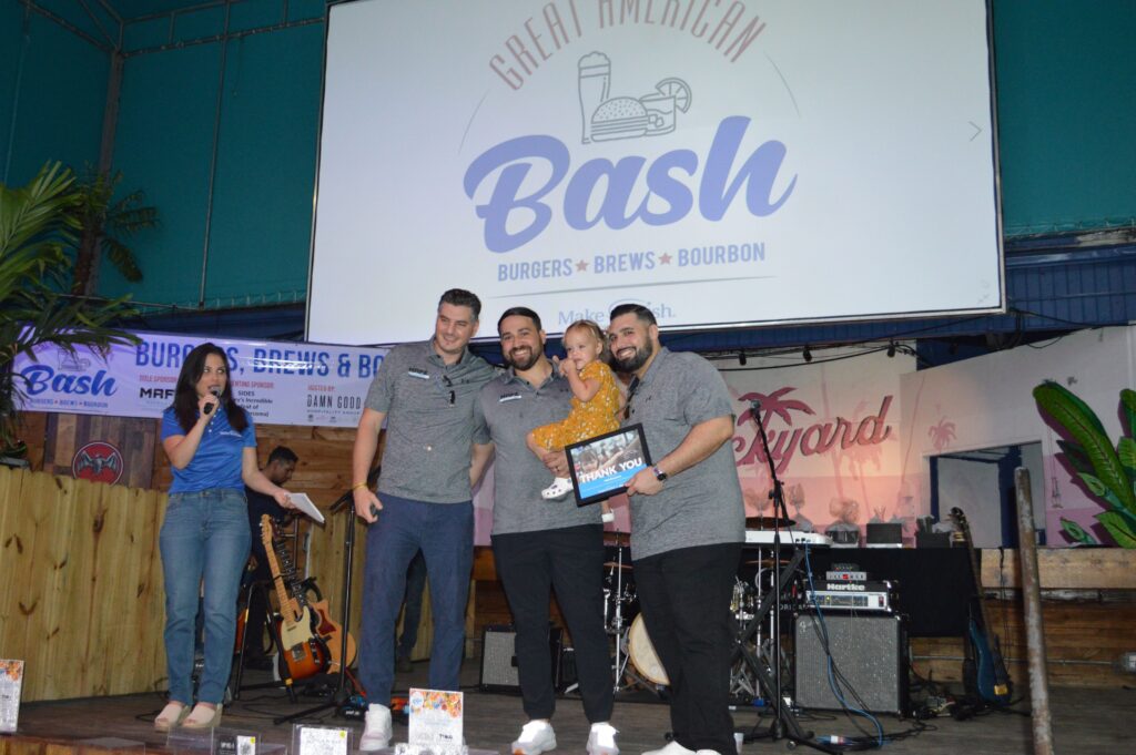 Three man and a kid standing on the stage